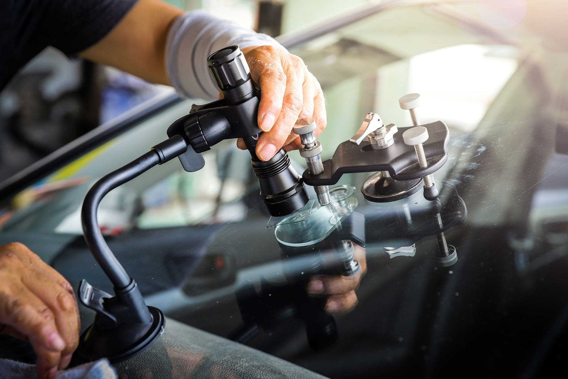 Man doing rock chip repair on car windshield